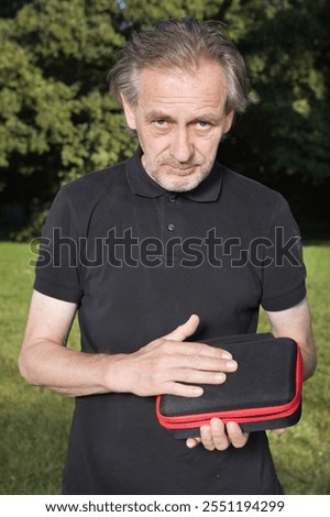 Older man uses two types of smoke machine generators on outdoor location