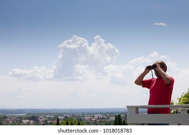 Older Man Using Binoculars On Roof