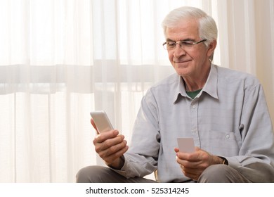 Older Man Using Credit Card For On Line Transaction