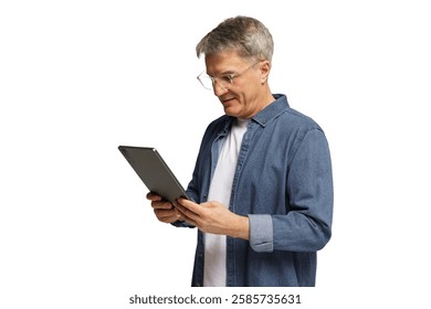 Older man using tablet while standing in a modern indoor setting during daylight hours