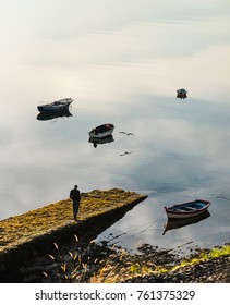 Older Man Walking By The Pier In The Morning (unrecognizable)