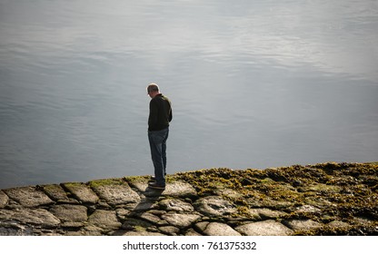 Older Man Walking By The Pier In The Morning (unrecognizable)