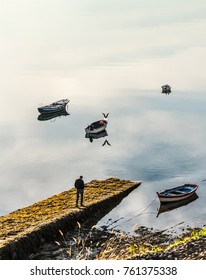 Older Man Walking By The Pier In The Morning (unrecognizable)