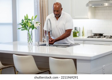 Older Man Washing His Hands In The Kitchen￼