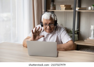 Older Man Wear Headset Start Videoconference At Home. Mature Male Use Laptop Greets Online Therapist, Welcoming Grownup Children Living Abroad. Distant Communication, Videocall Event, E-health Concept