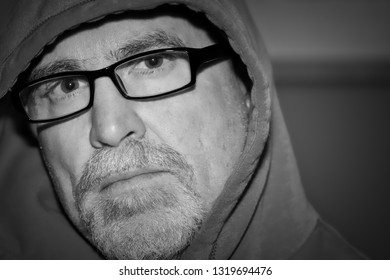 Older Man Wearing Glasses Staring Ahead In Black And White Portrait