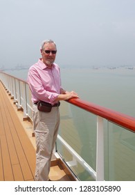 Older Man, Wearing Sunglasses Standing At The Railing Of Cruise Ship