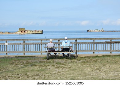 Older Man And Woman Fishing On Pier