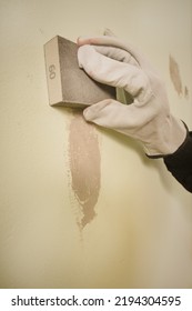 Older Man Working In Empty Apartment Sanding Repair Walls Before Painting