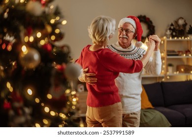 Older married couple dancing and holding hands while enjoying their Christmas Eve at home - Powered by Shutterstock