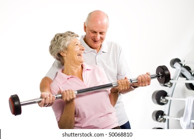 Older Mature Couple Lifting Weights In The Gym