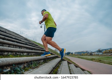 Older Mature Man In Good Shape During A Running Up Stairs Exercise