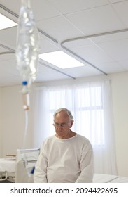 Older Patient Sitting On Bed In Hospital Room