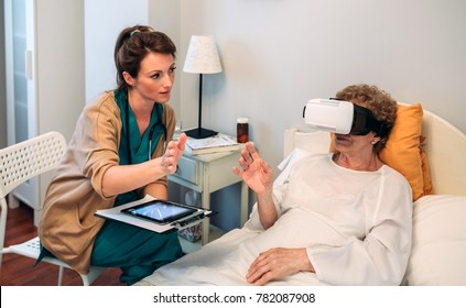 Older patient using virtual reality glasses to see her spine while female doctor explains