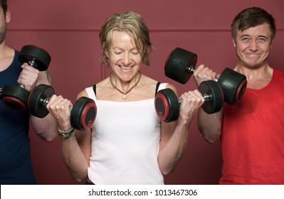 Older People Lifting Weights In Gym