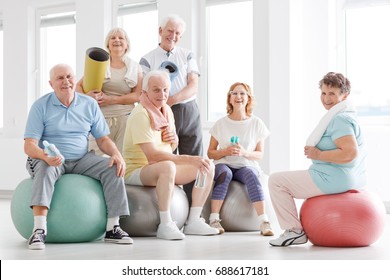 Older People Smiling And Posing For A Photo At The Gym