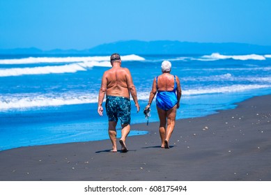 Older People Walking Along The Beach. Costa Rica, Tourist Paradise