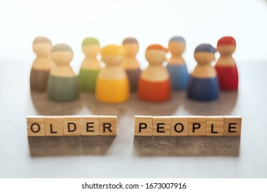 OLDER PEOPLE word on wooden blocks with a group of different people in the background - Shutterstock ID 1673007916