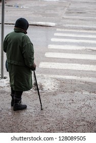 Older Person Crossing A Slippery Street At Winter