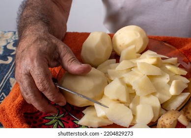 
Older Person's Hands Cutting Potatoes For Spanish Omelette