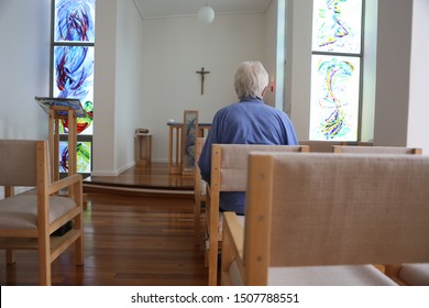 Older religious sister sits in a modern chapel