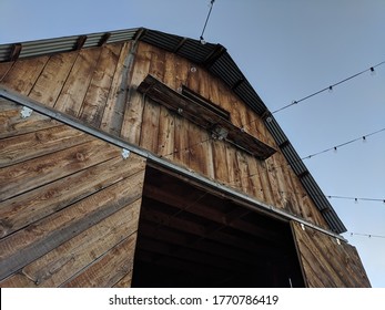 Older, Rustic Barn Being Prepared For A Wedding . Lights Strung From The Top.