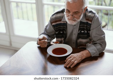 Older Sad Man Eating Dinner Alone In The Apartment