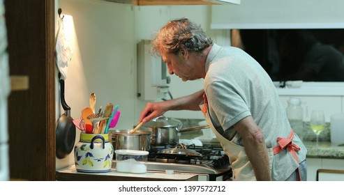 Older Senior Man Cooking At The Kitchen, Candid Chef.