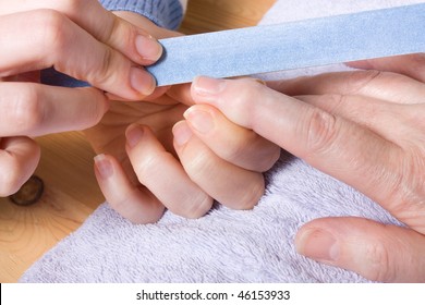 Older Senior Woman With Arthritic Hands Receiving Home Spa Treatment / Manicure.