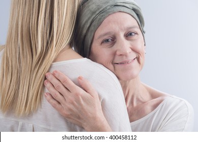 Older Sick Smiling Woman With Cancer Hugging With Her Young Daughter