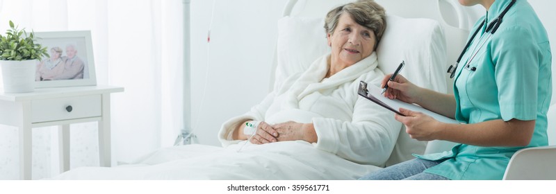 Older Sick Woman In Hospital Bed And Her Nurse