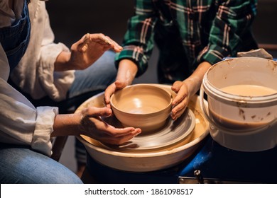 the older sister and her younger brother spend time in a pottery workshop, making clay dishes - Powered by Shutterstock