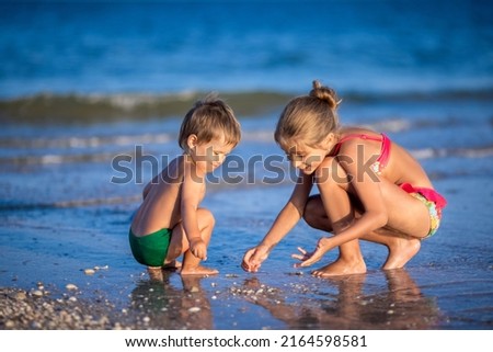 Similar – Two kids digging on the beach