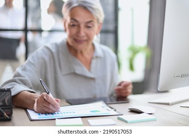 The Older Stylish Woman Takes Notes In A Document