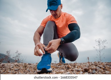 Older Well Built Man In Activewear Tying The Shoelaces Of His Athletic Shoes