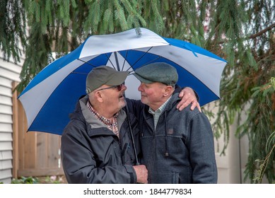 Older White Male Gay Couple Under An Umbrella.