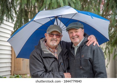 Older White Male Gay Couple Under An Umbrella.