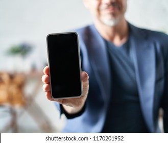 Older White Man Showing Smart Phone With Blank Screen.