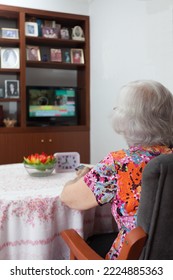 Older White-haired Woman Watching TV In Her Living Room, Loneliness Of The Elderly, Connectivity With The Outside World.