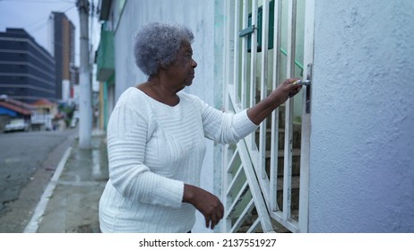An Older Woman Arriving Home Opening Front Gate And Entering House
