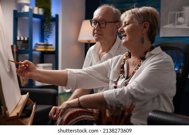 Older woman art teacher explaining freehand technique to elderly man learning pencil drawing in workshop. Senior artist studying shading on still nature object sketching on paper on easel. - Powered by Shutterstock