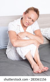 Older Woman In Bed With Stomach Pain