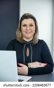 Older Woman With Blonde Hair Sitting In Front Of A Computer, Experienced Businesswoman In Her Office