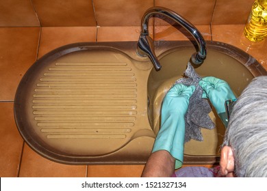 Older Woman Cleaning Dishes In The Kitchen