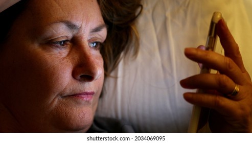 Older Woman Close-up Face Looking At Cellphone Screen At Night, Blue Light Glow