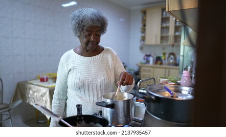 A Older Woman Cooking At Kitchen Stirring Pot