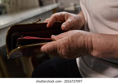 The Older Woman Counts The Money. An Elderly Woman Caucasian Old Woman Gray-haired Grandmother Takes Money Out Of Her Purse And Counts It. Old Hands Hold Bills. 