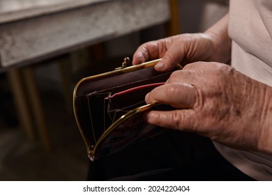 The Older Woman Counts The Money. An Elderly Woman Caucasian Old Woman Gray-haired Grandmother Takes Money Out Of Her Purse And Counts It. Old Hands Hold Bills. 