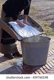 Older Woman Does The Laundry In An Old Wooden Board