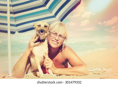 An Older Woman And Dog On The Beach